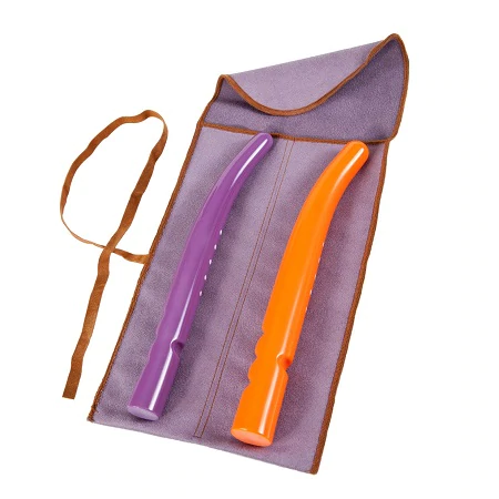 A purple and an orange Soul Source Gender Reassignment Surgery dilators from the small set lie on a purple mat with brown trim and straps.